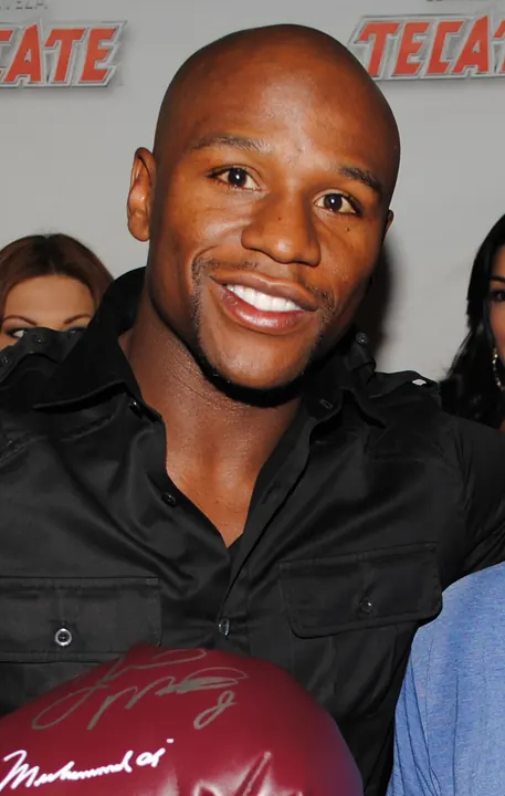 Portrait of a smiling Floyd Mayweather Jr. in a black shirt